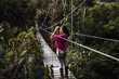 © Luis Herrera/Stocksy - Woman Walking Through A Hanging Bridge