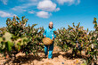 © Ezequiel Giménez/Stocksy - Senior farmer with basket walking near vines