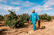© Ezequiel Giménez/Stocksy - Farmer with basket walking on vineyard