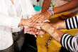 © Guille Faingold/Stocksy - Diverse business women stacking hands.
