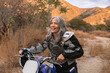 © Jordana Sheara/Stocksy - Mature woman happy outdoors on a dirtbike