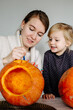 © Sergey Narevskih/Stocksy - Woman with child making lantern from pumpkin