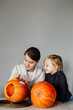 © Sergey Narevskih/Stocksy - Mother and daughter outlining stencil on pumpkin