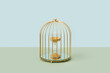 © Yaroslav Danylchenko/Stocksy - Hourglass with golden sand inside birdcage.