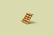 © Yaroslav Danylchenko/Stocksy - Golden bars ladder on yellow background.