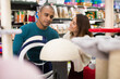 © JackF - Positive young adult man and woman shopping together searching bed for cat in store