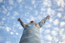 Tween Girl Reaches Into A Big Blue Sky With White Clouds.