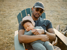 A Father Holding His Sleeping Son Outdoors