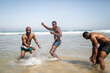 © Lupe Rodríguez/Stocksy - Group of male friends having fun on the beach