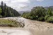 © Andriy Bezuglov/Stocksy - Mountain river with muddy water between green trees