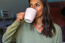 Authentic woman having coffe and looking out the window