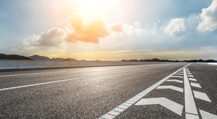 Empty asphalt road and beautiful mountain with colorful sky clouds at sunrise