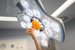 © Santi Nuñez/Stocksy - Surgeon Fixing Surgical Lamp Near Patient