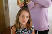 Young Girl Sits While Having Her Hair Curled