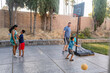 © ByLorena/Stocksy - Family play basketball in backyard