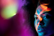 © David Prado/Stocksy - Serious black lady looking away in purple neon studio