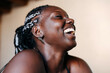 © Lucas Ottone/Stocksy - Close up portrait of laughing black woman