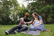 © Rob and Julia Campbell/Stocksy - Young family on blanket together in the park.