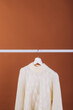 © Painted Wood/Stocksy - Single white sweater on a hanger