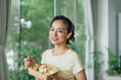 © Marc Tran/Stocksy - female worker in office having healthy salad lunch at desk