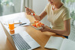 © Marc Tran/Stocksy - woman eating salad lunch at the office