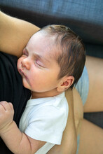 Sleeping Newborn Baby In Mom's Arms