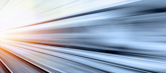 Blue high speed train runs on rail tracks - The train is going too fast as a result the air pressure is causing too much heat at the front