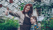© silverkblack - Pretty woman owner of greenhouse and her cute daughter are taking selfie with smartphone inside orchard, posing and smiling. People and modern technology concept.