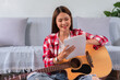 © snowing12 - Hobby concept, Young asian woman is composing song to create new song with playing acoustic guitar