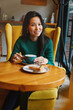 © olga pink - Portrait of young Asian woman drinking coffee witn apple pie in cafe