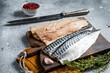 Cooking of fresh raw mackerel fillet fish on a cutting board. Gray background. Top view