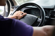 © Nattawit - Action of a driver hand is holding and controlling on car's steering wheel during driving, photo from behind. Transportation occupation service with people part, selective focus.