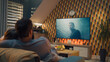 © Framestock - Couple on sofa in living room, watching action movie on TV or criminal blockbuster on streaming service, talking and discussing acting, resting at home on weekend. Home theater in modern apartment.