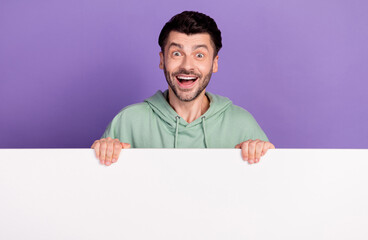 Poster - Photo portrait of nice young man excited stand behind white wall banner wear trendy gray garment isolated on violet color background