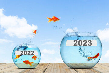 Wall Mural - Fish jumping to big aquarium with 2023 numbers