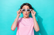 Photo of excited speechless staring girl with bob hairdo pink t-shirt hands hold sunglass impressed news isolated on teal color background