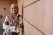 © Drobot Dean - Happy muslim businesswoman standing by wall while working in office