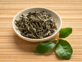 Canvas Print - Dried white monkey tea leaves, Bai Mao Hou, close up in a bowl with fresh tea leaves in front