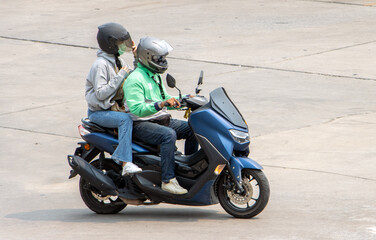 The pair rides on motorcycle at the street.