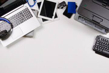 Top view to old laptop computers, digital tablets, mobile smart phones, printer, many used electronic gadgets devices on white background. Planned obsolescence, electronic waste for recycling concept