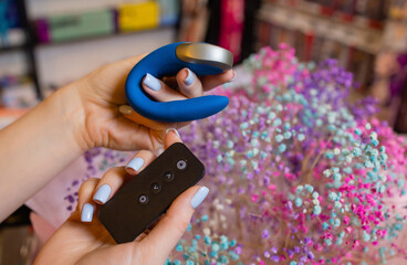 Girl's hand holds a massager for sex. Vibrator for masturbation. Dildo for vaginal and clitoral stimulation. Image for sex shop.