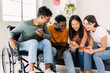 © Xavier Lorenzo - Group of diverse teenage people using mobile phone - Inclusion and diversity concept with young indian man in wheelchair having fun with multiracial friends watching social media content on cellphone