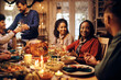 © Drazen - Happy black woman talks to friends during Thanksgiving meal at dining table.