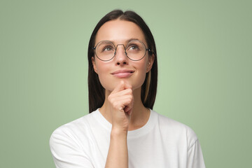 Wall Mural - Closeup of woman dressed in white T-shirt, wearing spectacles and dreaming about something pleasant