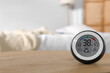 © New Africa - Digital hygrometer with thermometer on wooden table indoors. Space for text
