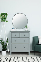 Sticker - Chest of drawers and stylish round mirror on white wall indoors. Interior design