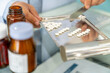 © CandyRetriever  - Medical pharmacy and healthcare providers concept. Asian man professional pharmacist counting drug pills on counting trays by hospital prescriptions on counter to patient customer in modern pharmacy.