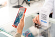 © CandyRetriever  - Medical pharmacy and contactless payment concept. Asian woman patient customer using mobile phone scan QR code on counter making online baking payment buying medicine and supplements in drugstore.