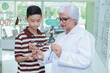 © ND STOCK - Middle-aged ophthalmologist examining young boy and giving eye consultation to Asian boy