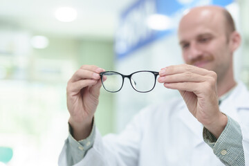 Wall Mural - male ophthalmologist with eyeglasses in clinic, closeup. Space for text